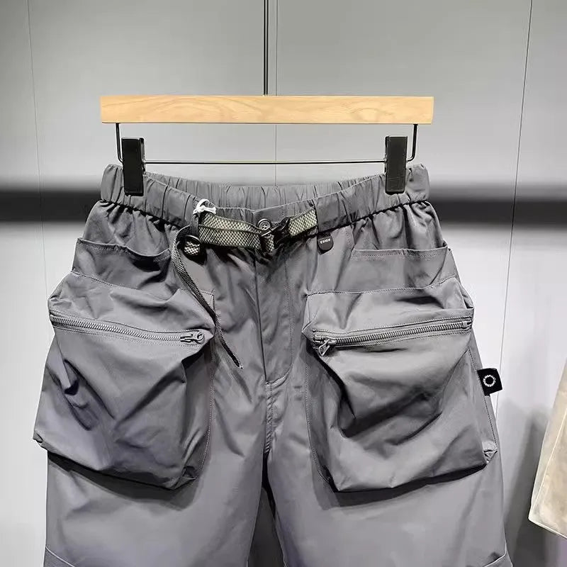 Men's solid black loose-fit work shorts with pockets, shown above the knee.