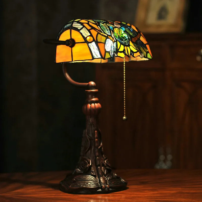Tiffany style table lamp with coloured stained glass shade on a resin base.