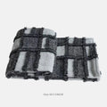 Modern minimalist bedding set with grey and white plaid blanket, pillowcase, and round pillow on bed