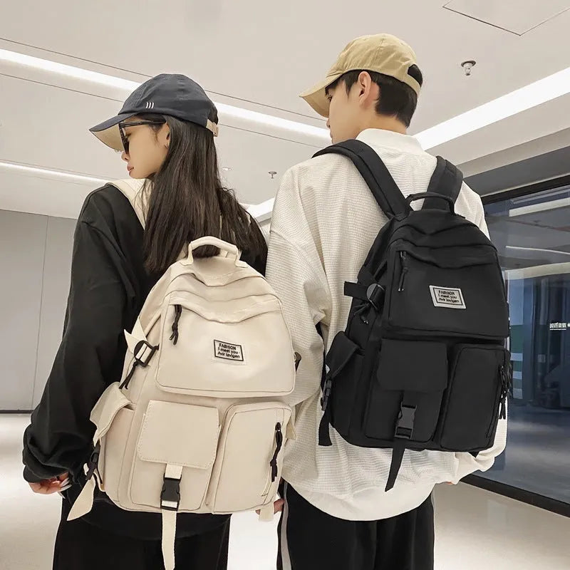 Black nylon student backpack showing front three-dimensional pocket and internal laptop compartment.