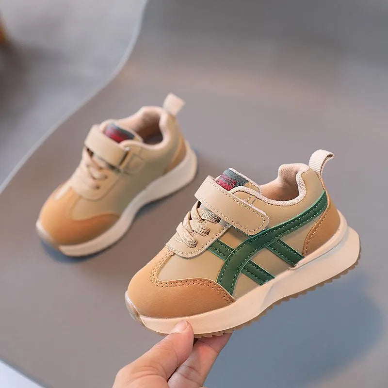 Children's white synthetic leather sneaker with Velcro strap on a rubber sole.