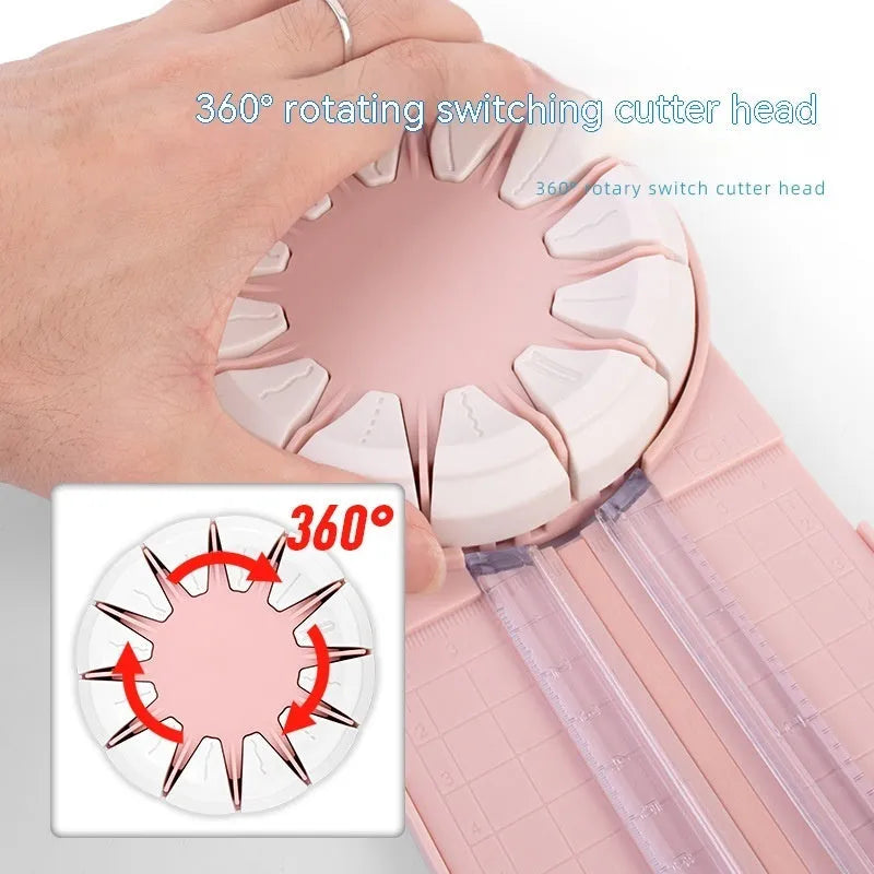 Pink and black 12-in-1 multifunctional plastic paper cutter with dotted guides on a cutting mat.