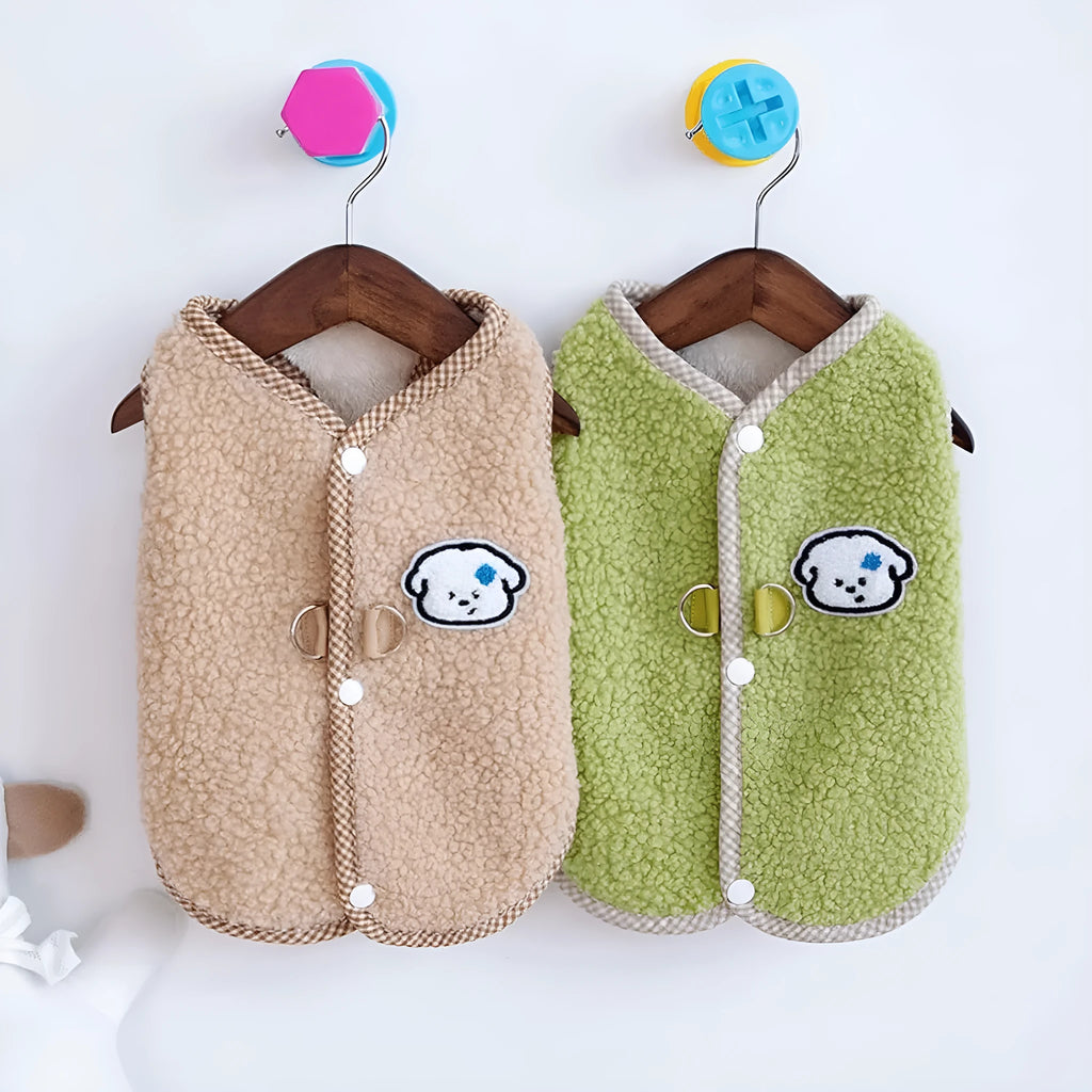 Green coral fleece dog vest with a metal leash ring on the back, fastened at the side on a small dog.