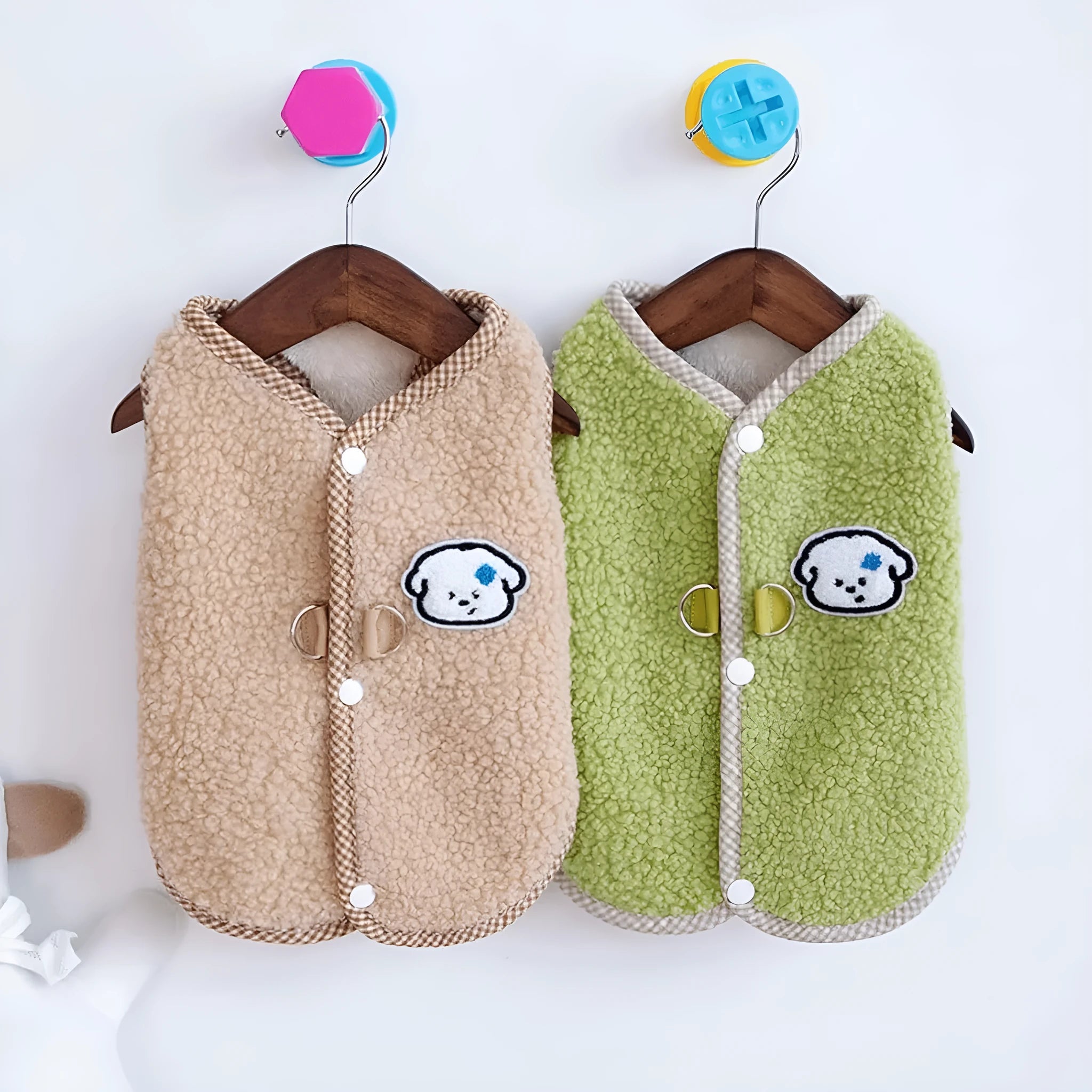 Green coral fleece dog vest with a metal leash ring on the back, fastened at the side on a small dog.