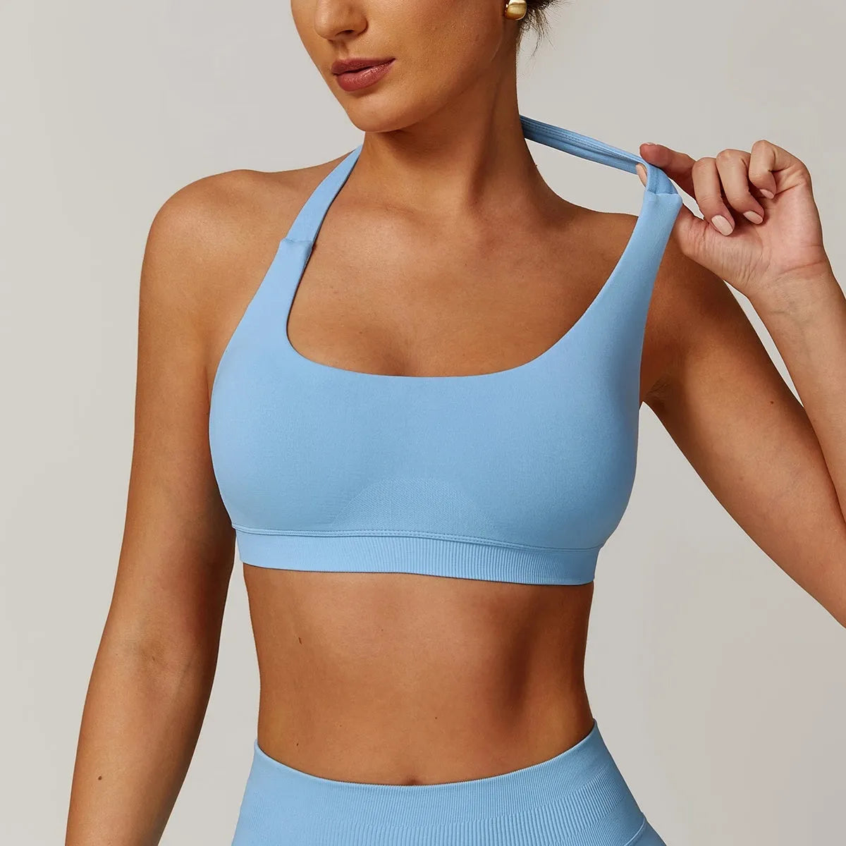 Women's black halter-neck sports bra for yoga and workouts with chest pads.