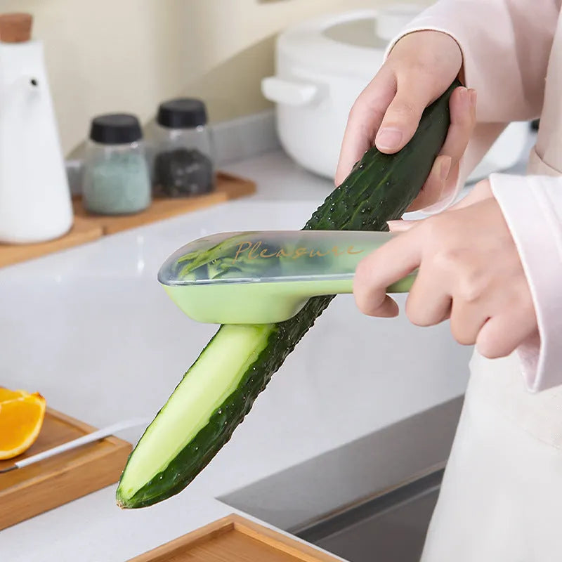 Dark green kitchen peeler with stainless steel blade inside its clear plastic storage tube