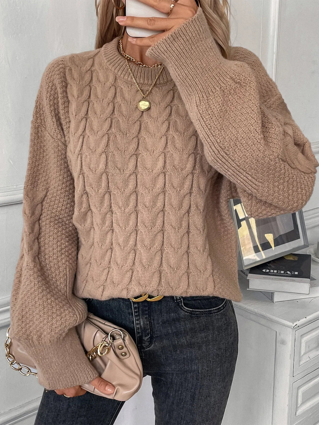 Beige women's loose round neck sweater with a twist design detail on the front.