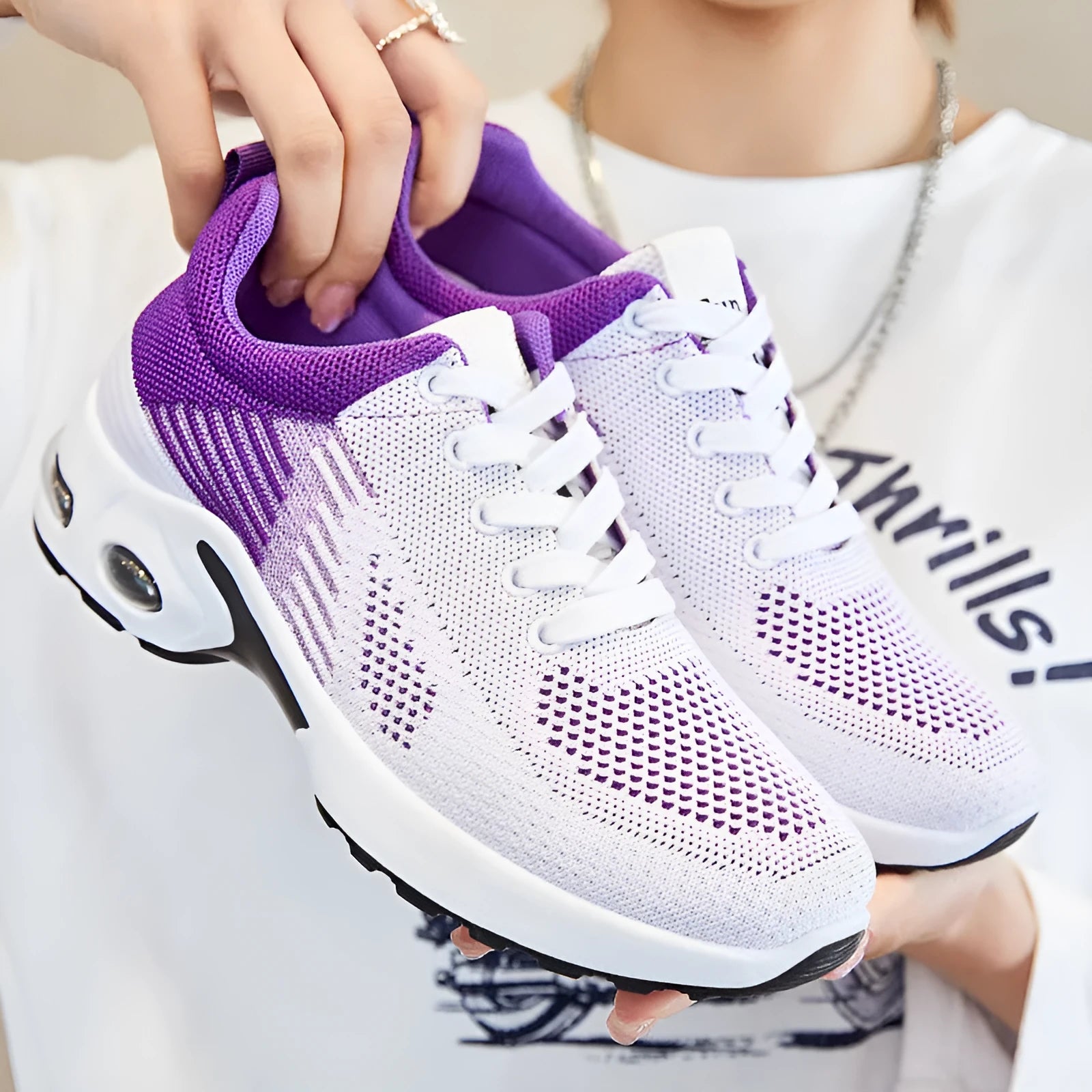 Women's pink flyknit running shoes with lace-up front, mesh lining, and flat PVC sole on a striped background.