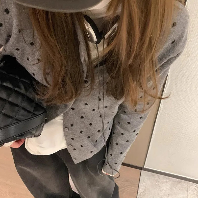 Women's grey dot pattern knitted cardigan with crochet flower detailing on mannequin
