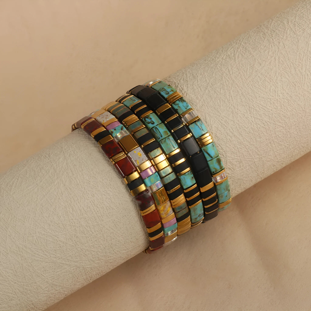 Adjustable geometric beaded bracelet with pull beads in milky white, black, green, blue or red.