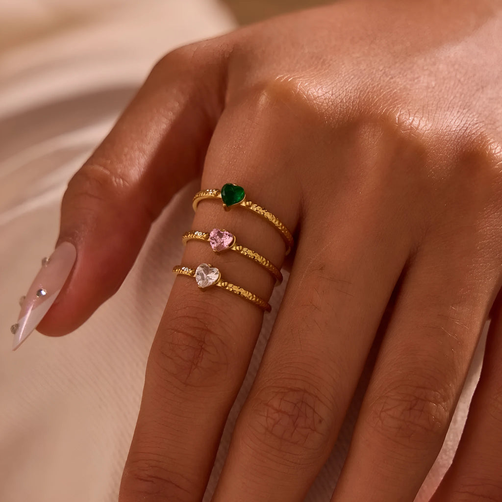 Open-ended stainless steel ring with a heart-shaped green zircon stone inlay on a geometric band.