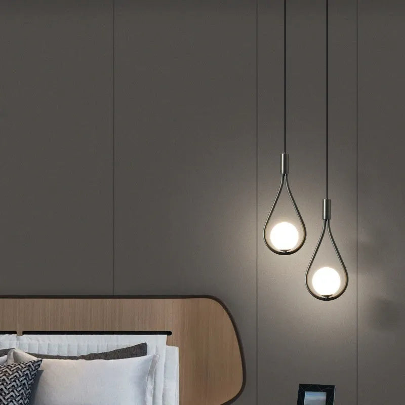 Modern copper bedside chandelier with adjustable hanging cord in minimalist bedroom setting