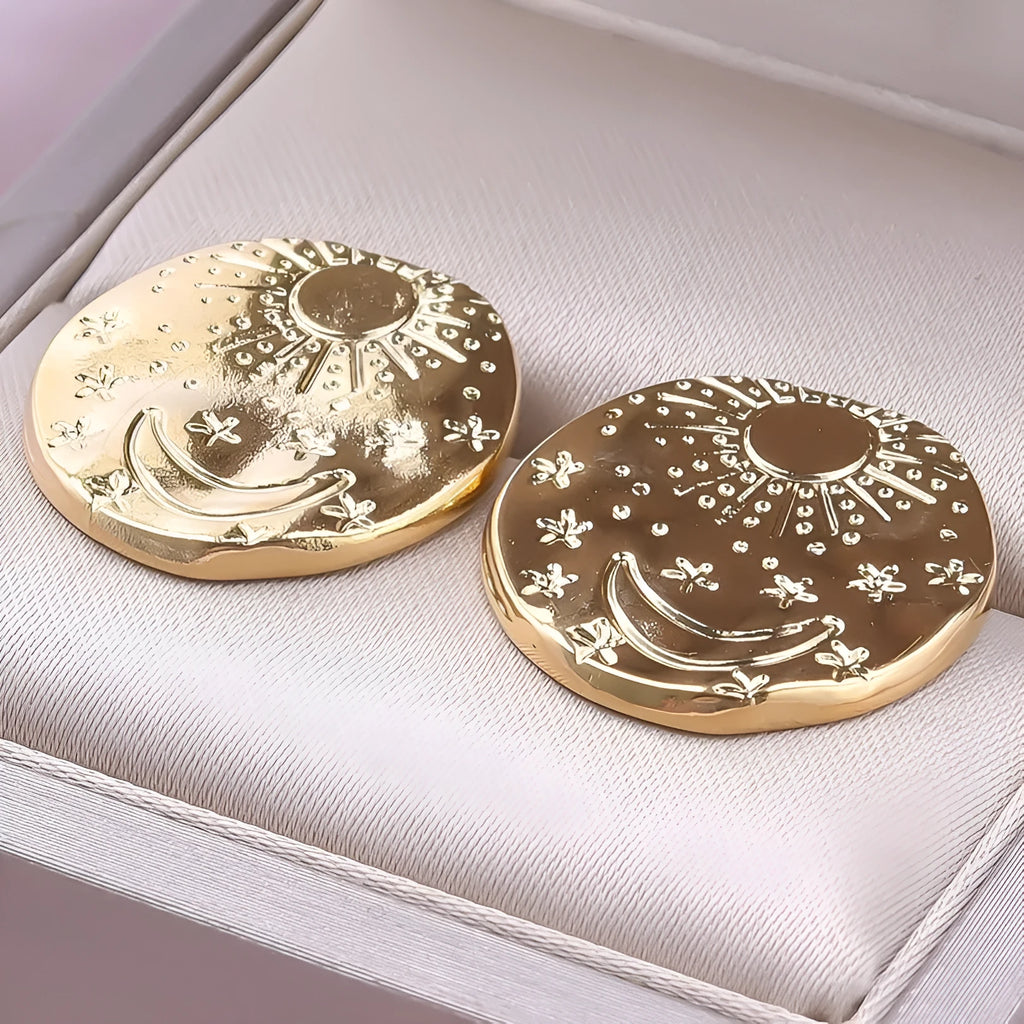 A pair of geometric shell-shaped stud earrings in stainless steel with a gold or silver electroplated finish.