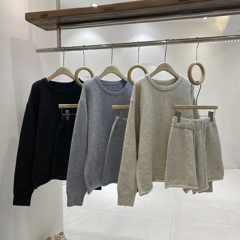 Women's loose-fitting knitted two-piece set showing long sleeve sweater and wide leg shorts in oatmeal colour