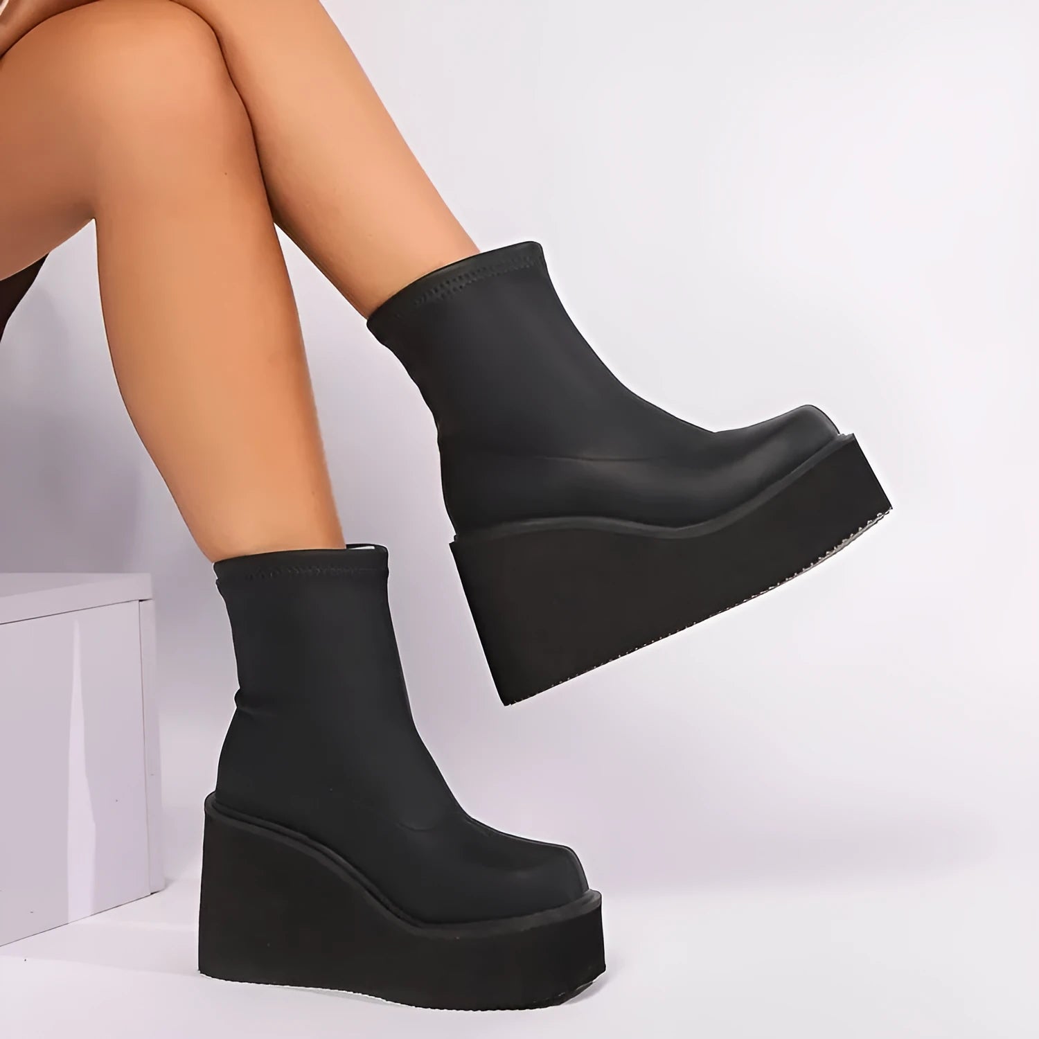 Plus size women's black ankle boots with a wedge heel and waterproof platform sole.