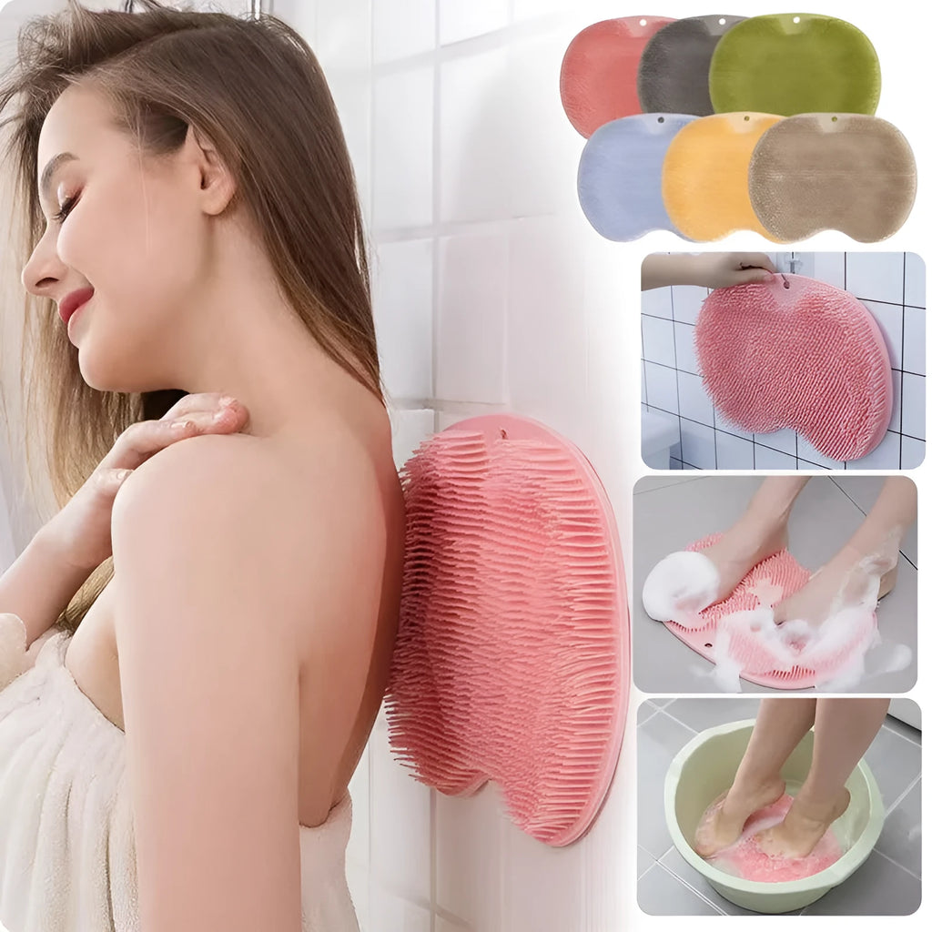 Orange non-slip massage bath brush with suction cups and soft silicone bristles on a bathroom floor.