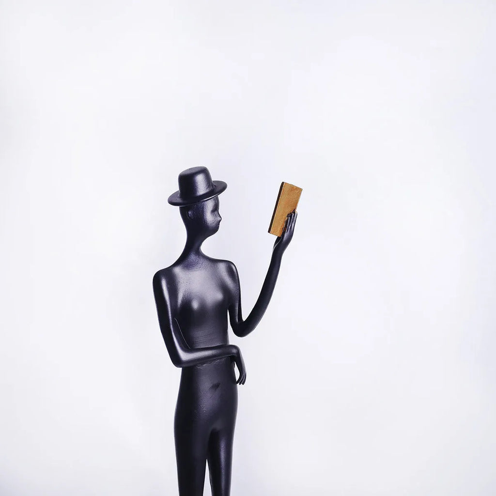 Black aluminium desktop sculpture of woman reading in modern style