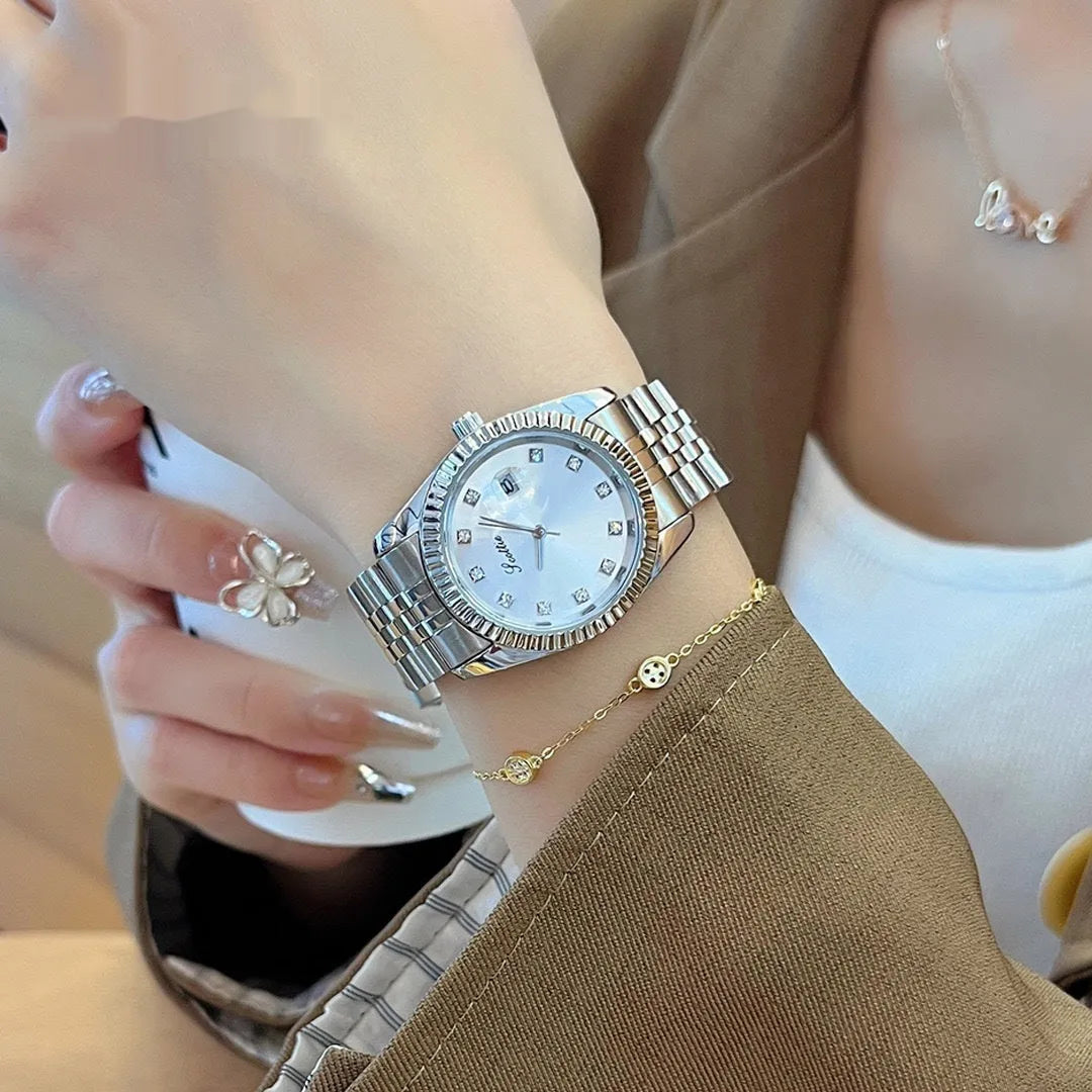 Women's casual analogue calendar watch with gold case, white dial, and steel belt on wrist