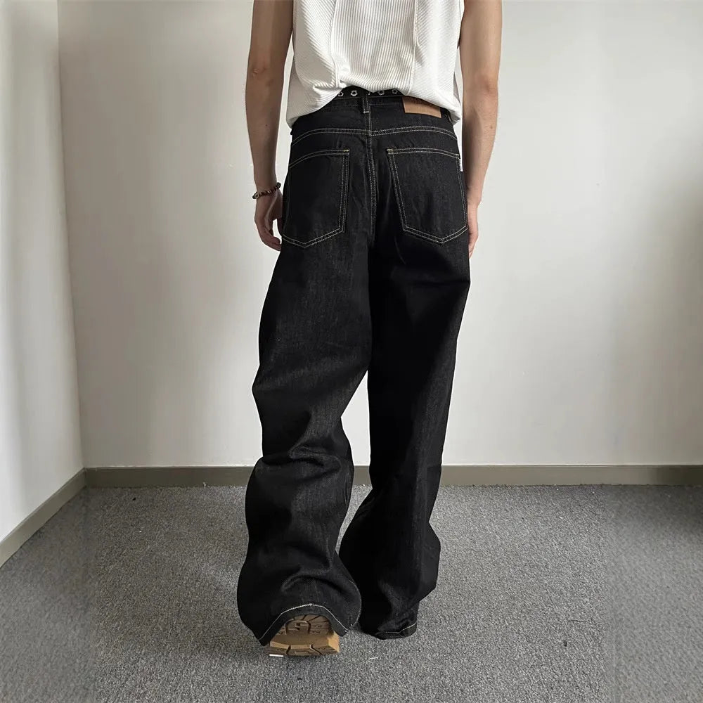 Black retro-style loose wide-leg straight-leg jeans on a hanger, showing mid-waist and zip fly.