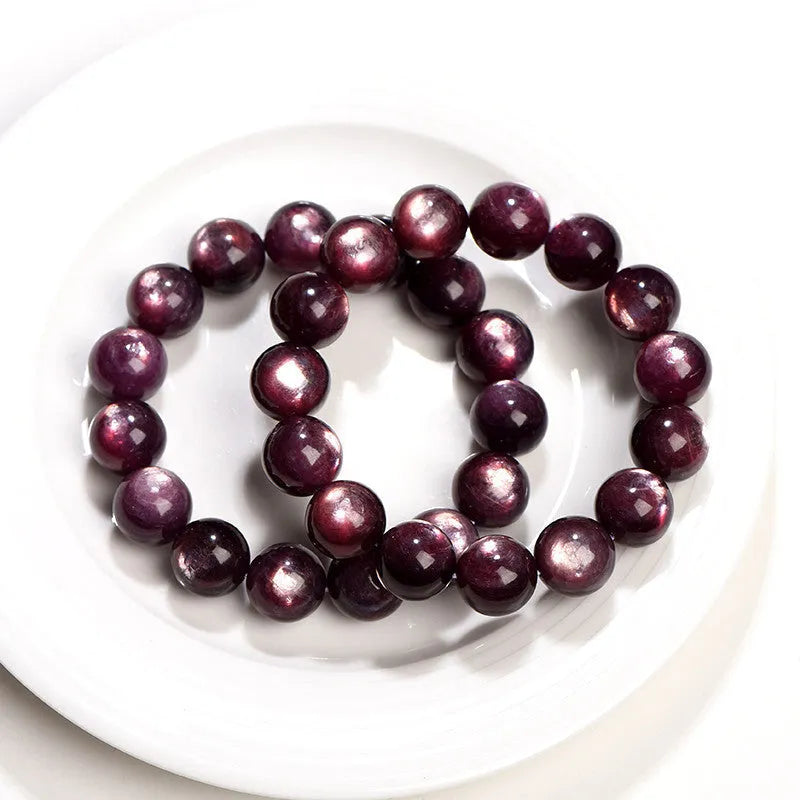 Purple lepidolite crystal bracelet showing polished round beads on adjustable string in natural lighting