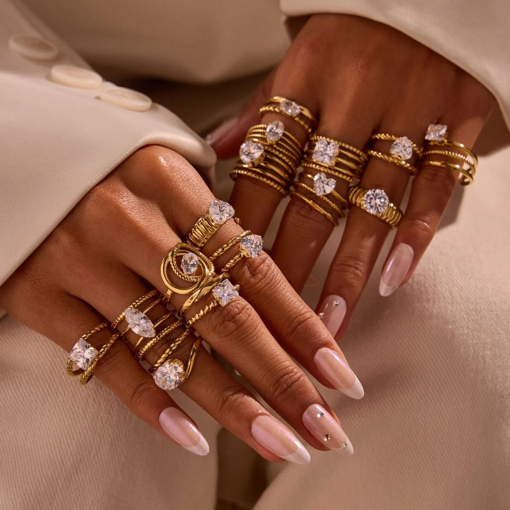 Gold-toned stainless steel ring with zircon details in a geometric heart shape design on a finger.
