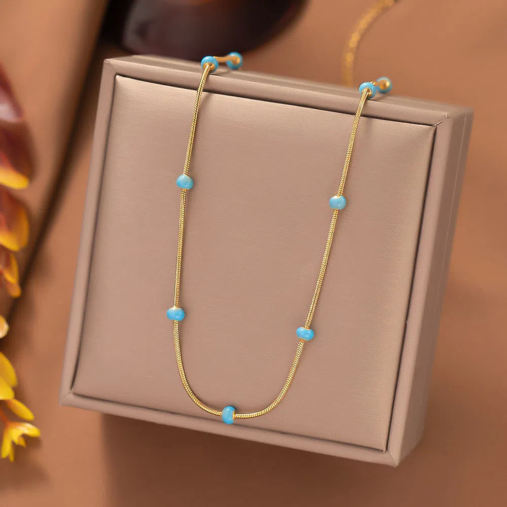 Titanium steel ball drop glaze necklace in green pearl gold, clavicle length, on model