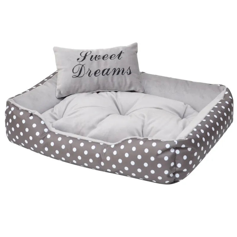 Polka dot print square dog bed with a matching embroidered pillow in grey, shown in a home setting.