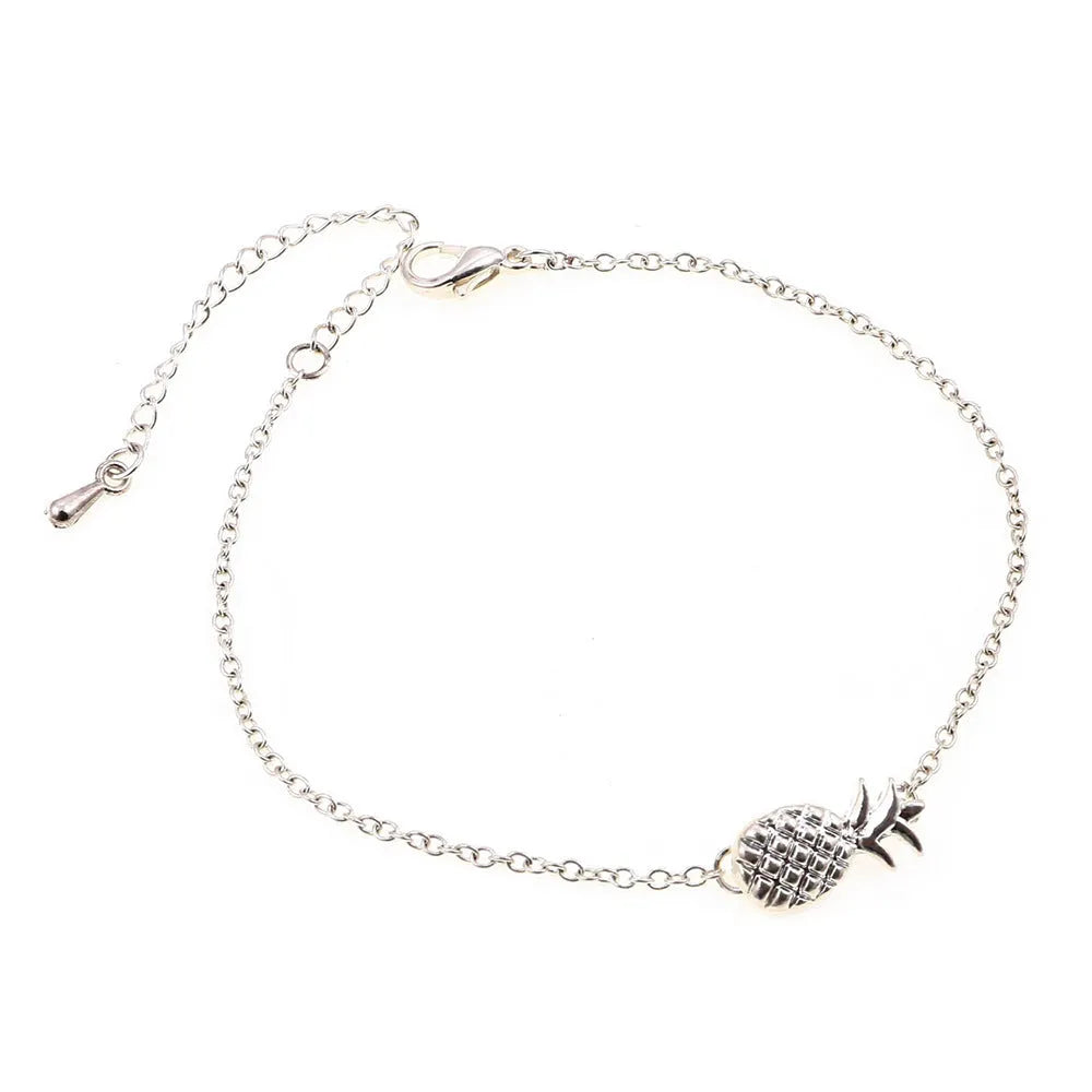 Women's alloy bracelet with a pineapple charm in gold or silver tone on a wrist.