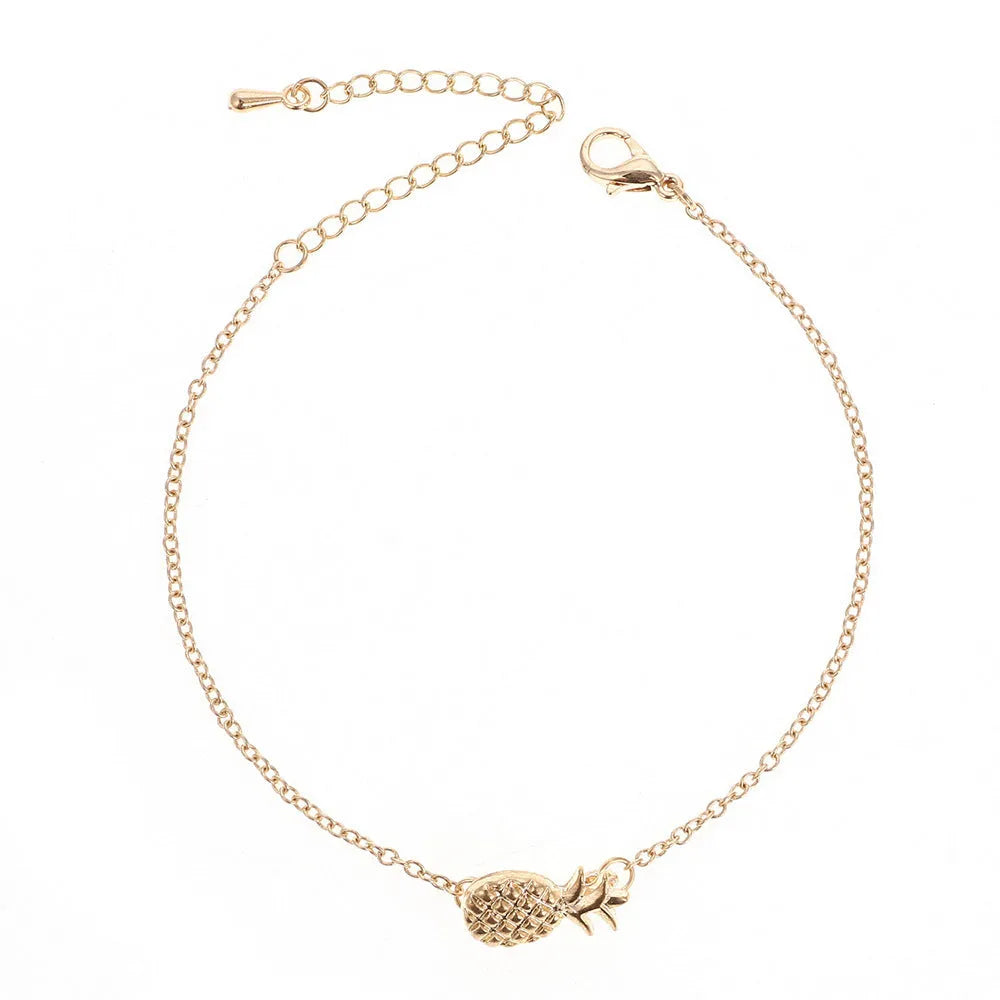 Women's alloy bracelet with a pineapple charm in gold or silver tone on a wrist.