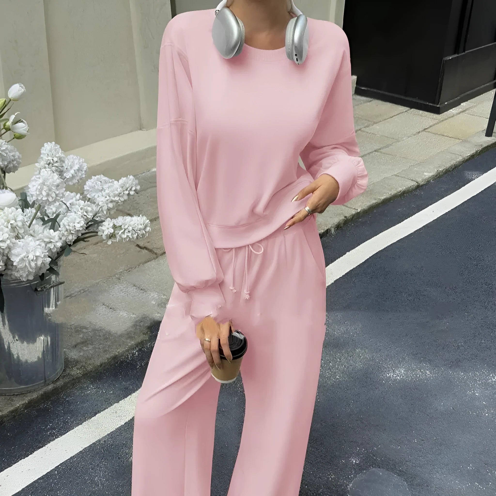 Women's solid colour casual trouser set with long sleeves in pink, showing top and trousers laid flat.