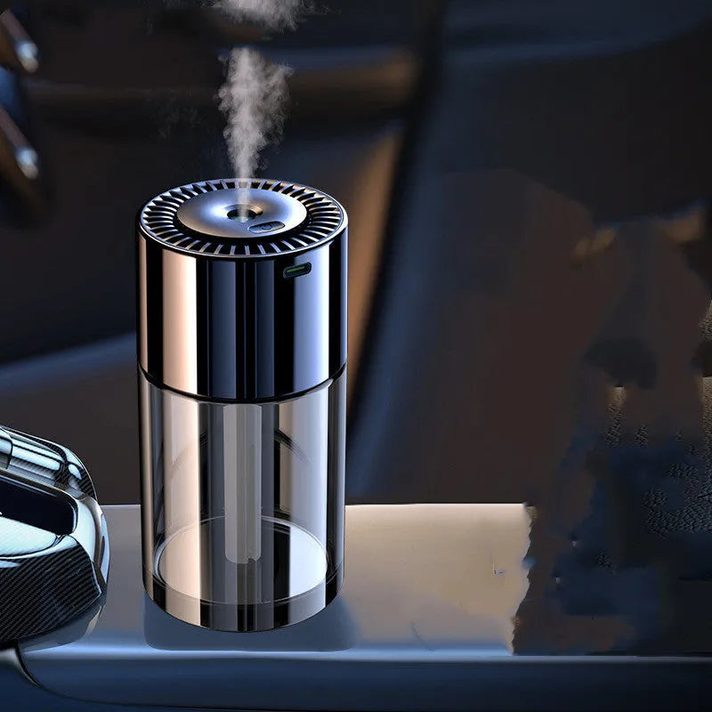 Compact USB plug-in spray perfume humidifier with glass seat on a desk.