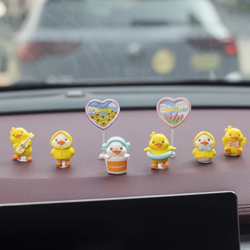 Six yellow PVC duckling car decorations with Hello sign on car dashboard