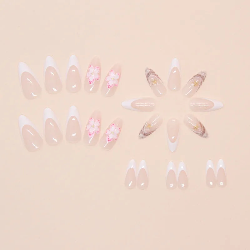 French style press-on fake nails with white tips and decorative pink rock-pattern floral patches on a clear nail bed.