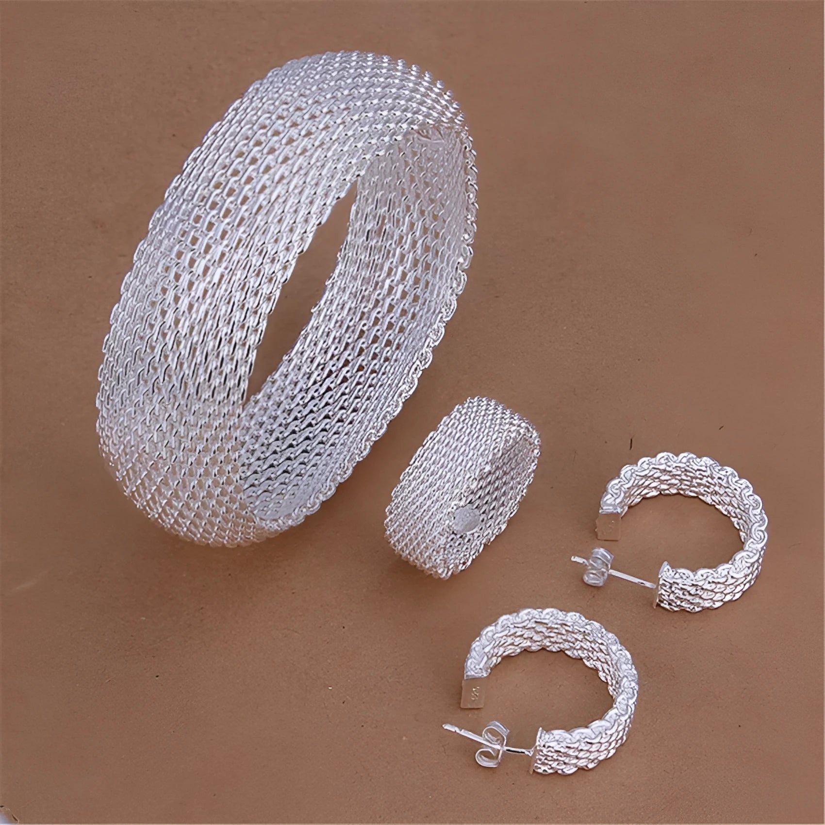 Retro copper net bracelet earring ring three-piece set on a flat surface
