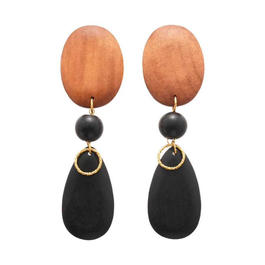 A pair of handmade brown and black wooden elliptical earrings in a retro style.