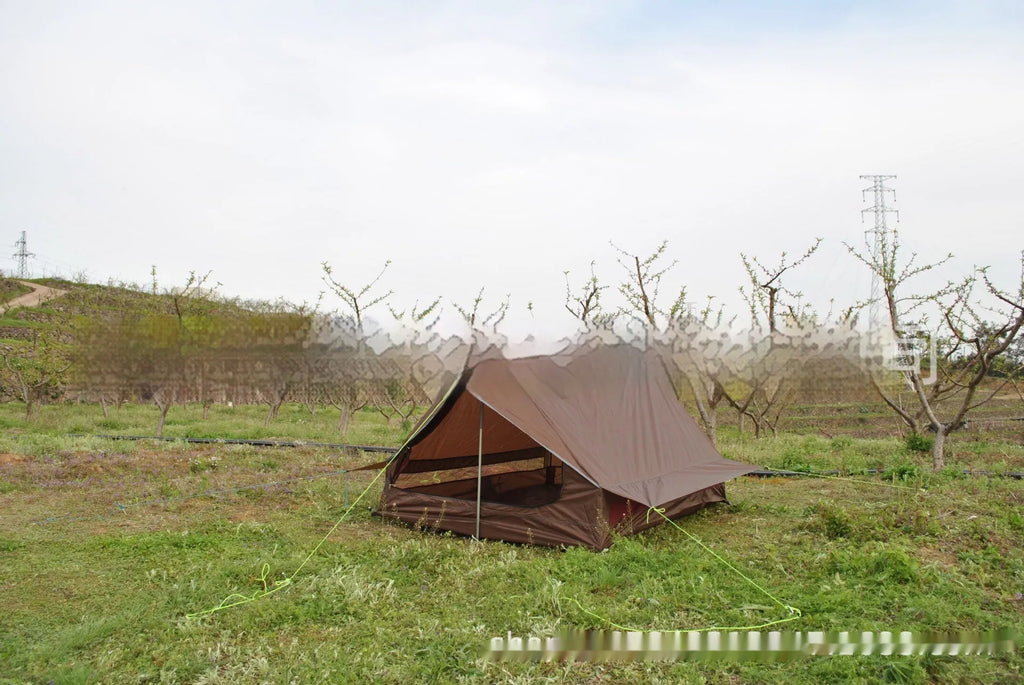 Brown A-line cabin tent pitched using hiking poles with aluminium ground nails and fluorescent wind ropes