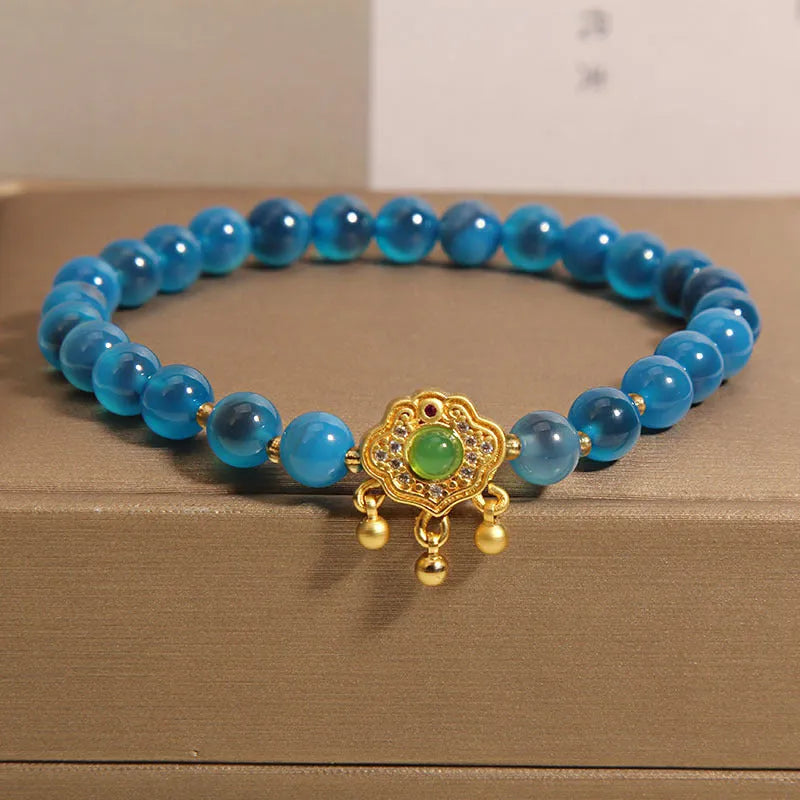 Blue agate safety lock pendant on a crystal women's bracelet with rhinestone details.