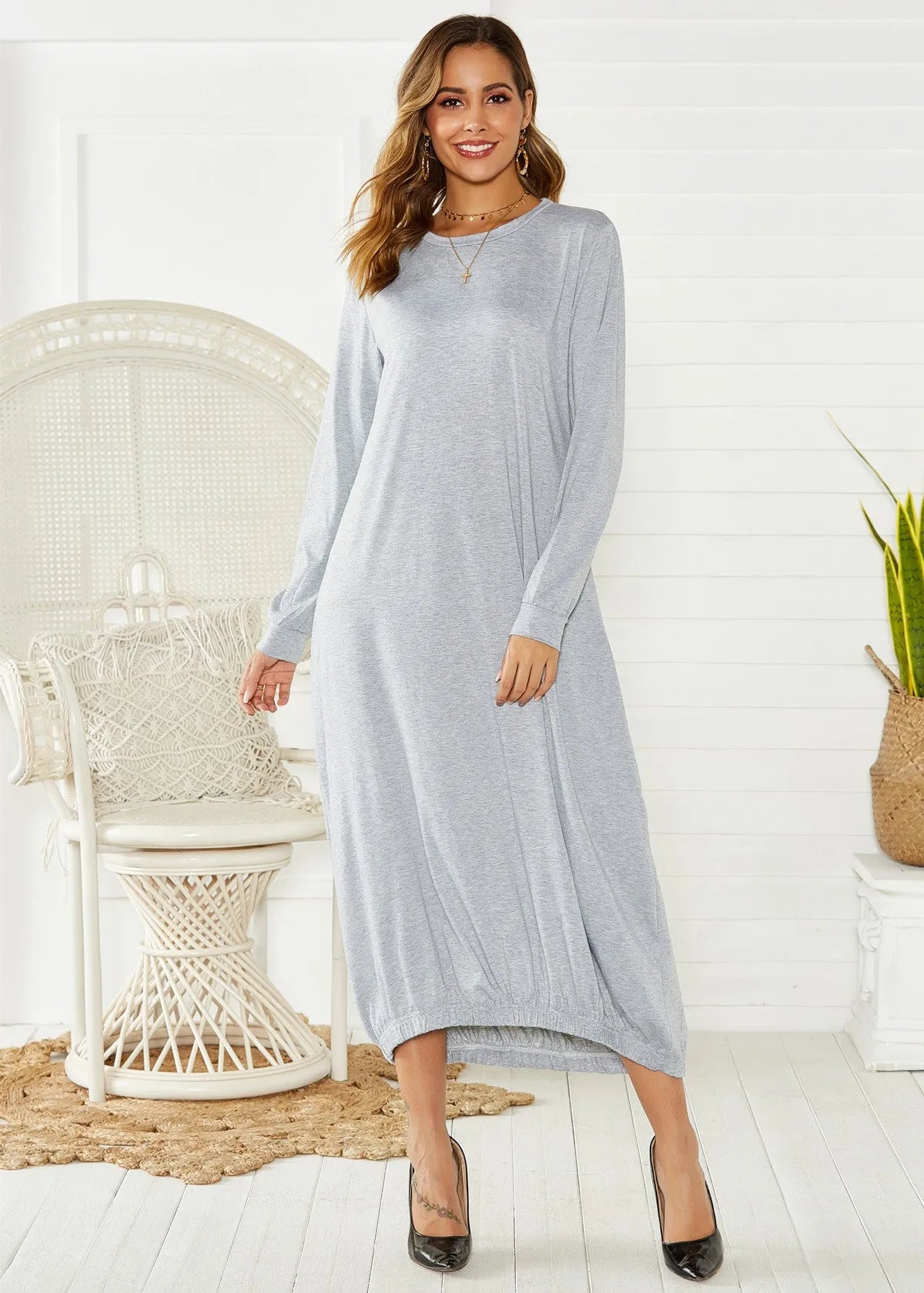 A loose black lantern dress with a lace-up crew neck, shown on a model.
