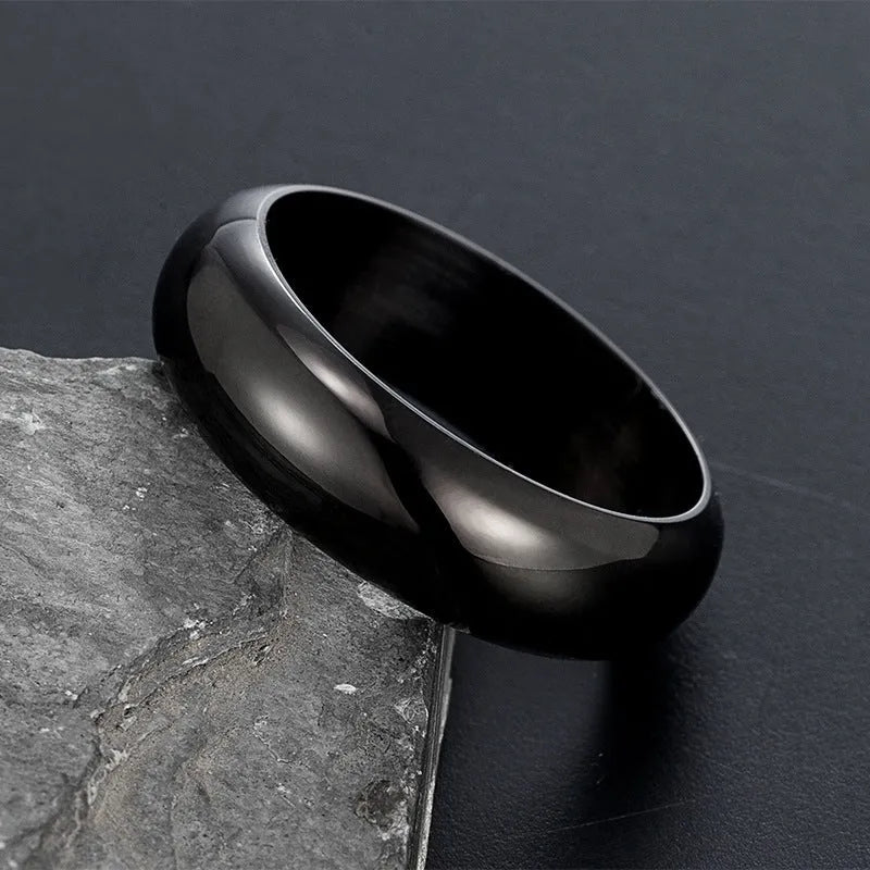 Glossy electroplated titanium steel ring in gold, black, and steel colours on a jewellery background.