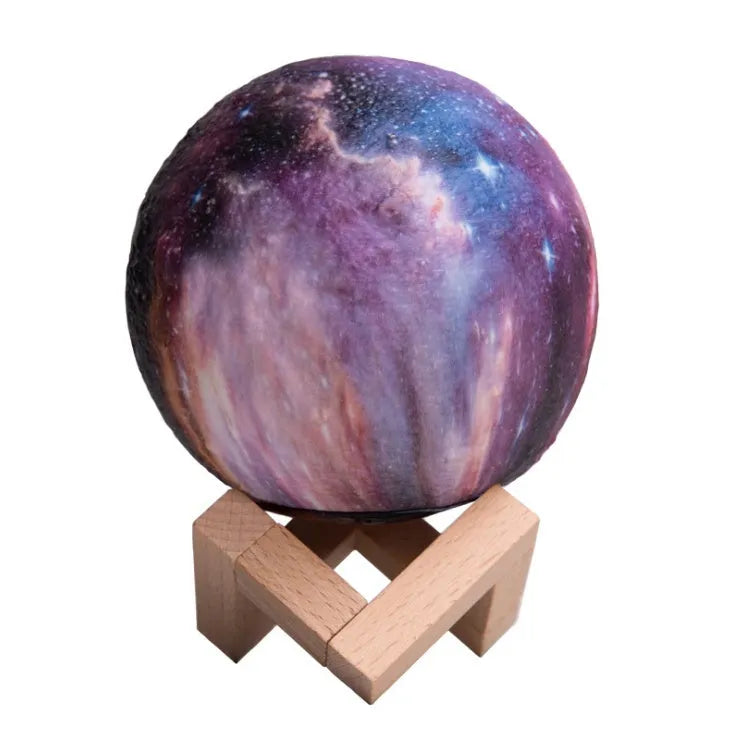 3D-printed spherical moon night light with colour-changing LED glow on a dark surface.
