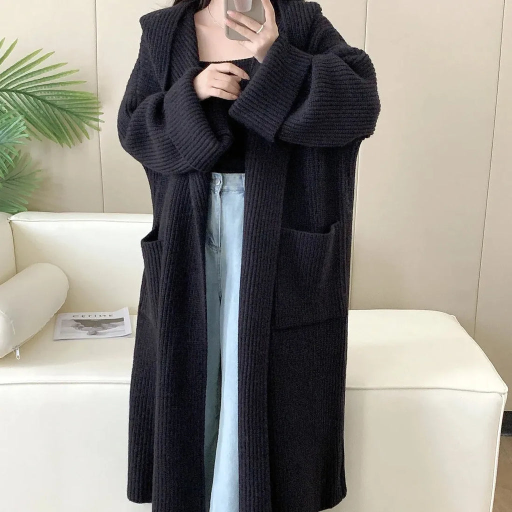 Loose grey hooded cardigan coat with raglan sleeves shown on a hanger.
