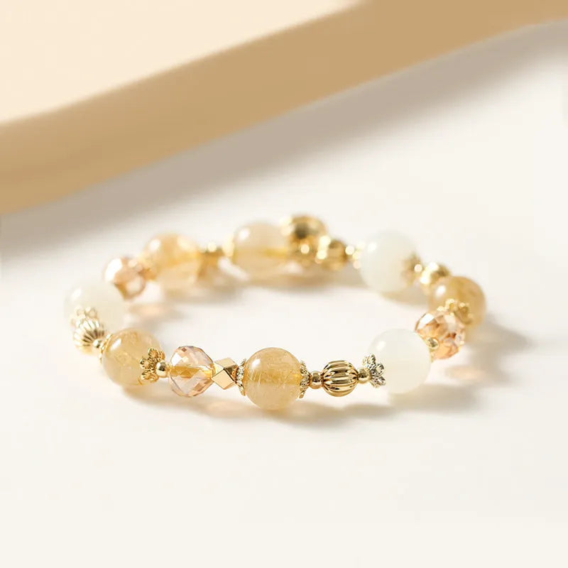 Gold electroplated bracelet with rutilated quartz and a ringing bell charm