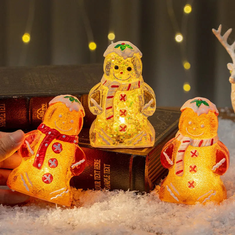 Glowing LED gingerbread man and snowman Christmas ornaments with coloured scarves on a festive tree branch.