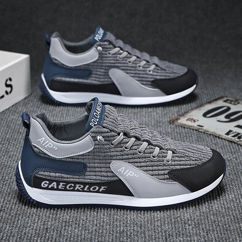 Men's grey mesh running shoes with round toe and lace-up closure on sports surface