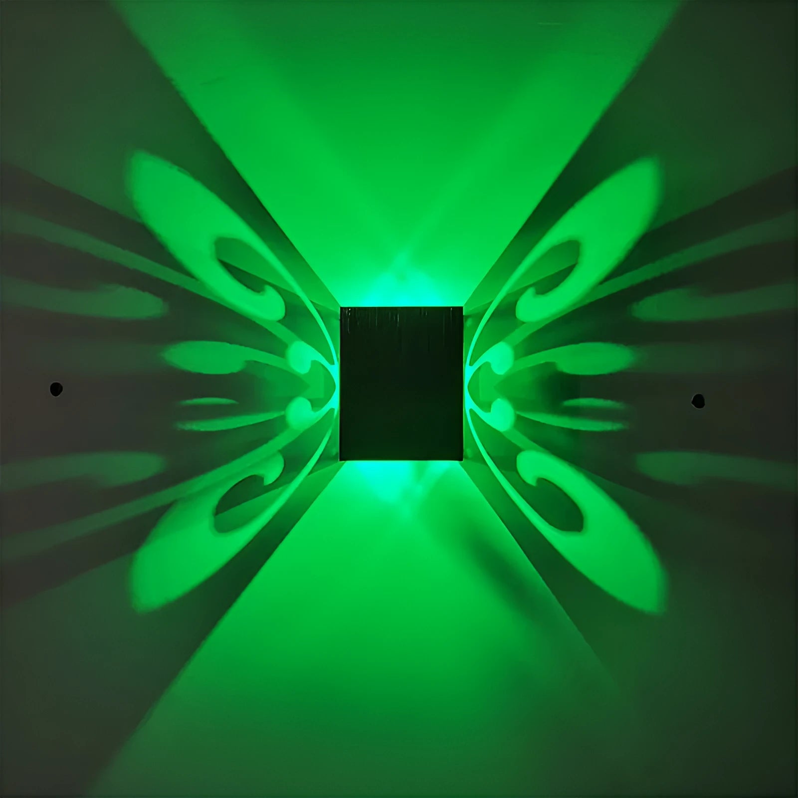 Modern aluminium butterfly-shaped LED wall lamp on a white wall with remote control.