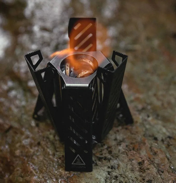 Hexagon-shaped foldable alcohol camping stove showing black finish and compact 9.5cm width