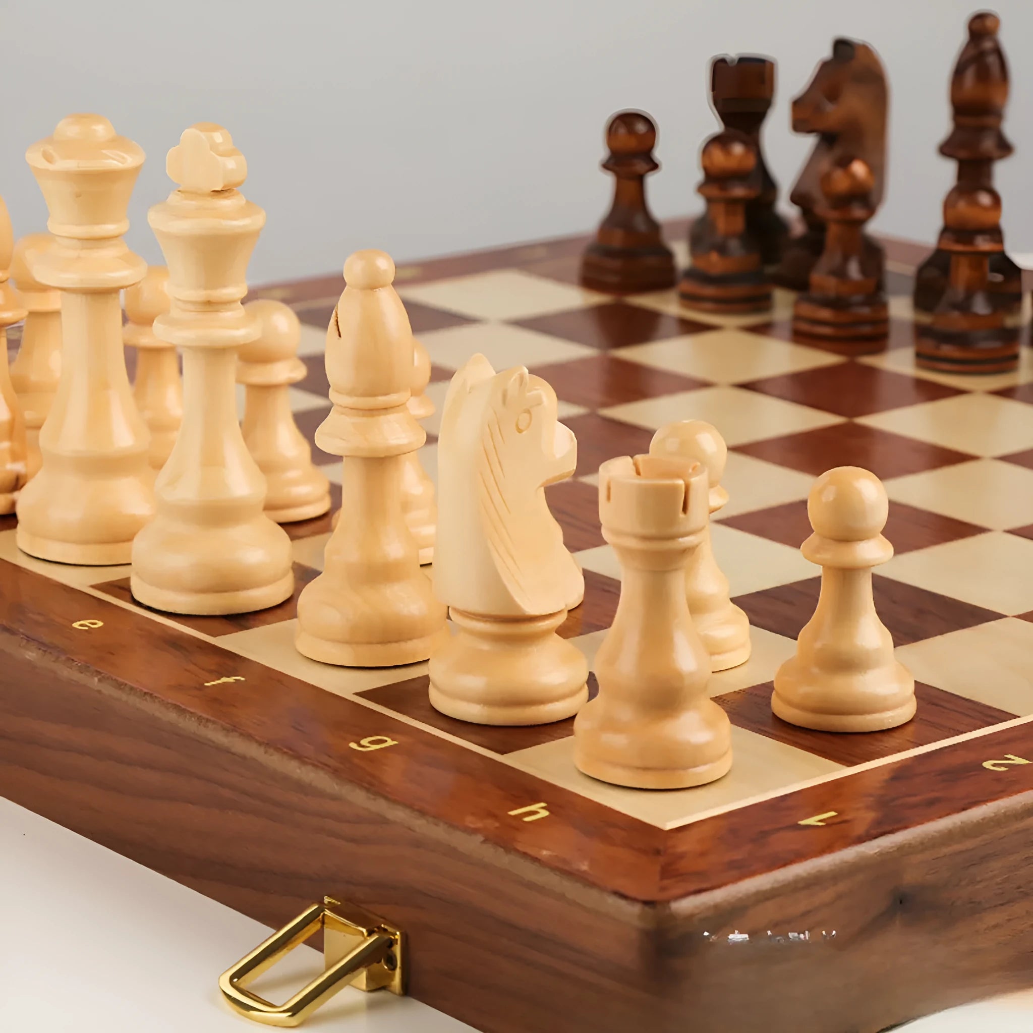 Walnut foldable solid wood children's chess set with brown board and pieces on wooden surface