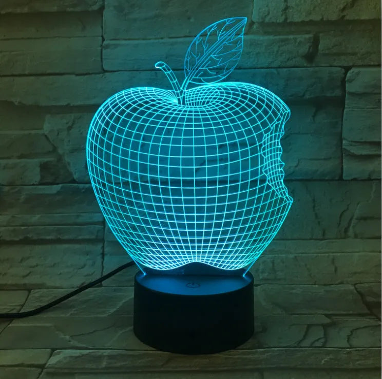 Colourful 3D fruit shaped acrylic LED night light with touch control on a table.