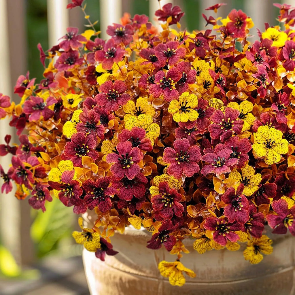 Artificial flower bouquet in autumn orange, yellow, and red colours with detailed plastic and silk construction