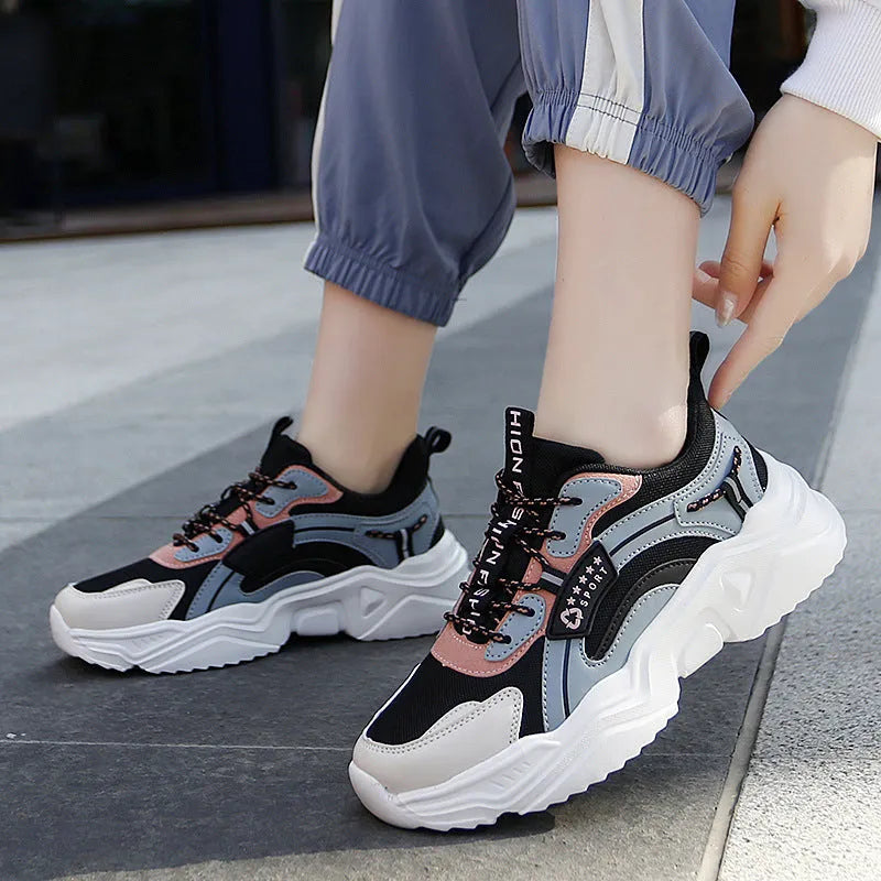White women's casual mesh sports shoe with thick sole, buckle detail, and round toe.